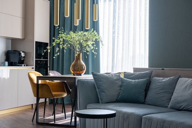 blue couch next to a small round dining table